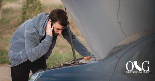 man looking under the hood of his car
