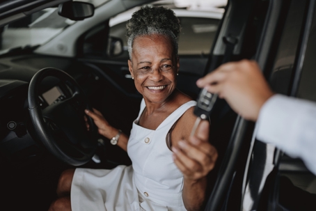 woman receiving keys to a new car