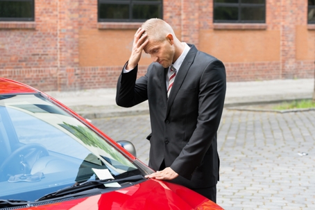 troubled man looking at his new car